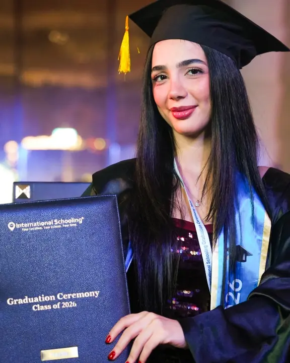 An International Schooling graduate in her cap and gown