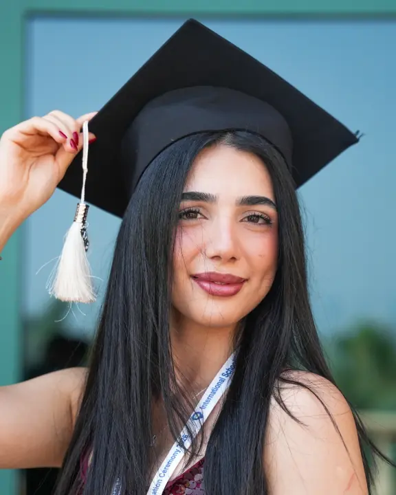 An International Schooling graduate in her cap and gown